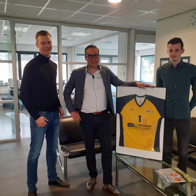 Tom van Asten mit zwei Mitgliedern von HOVAC und dem Volleyball-Shirt mit Sponsorenlogo